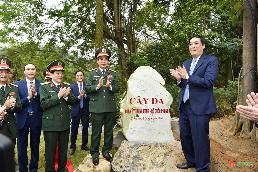 Các đại biểu bên bia đá ghi nhận cây đa do lãnh đạo Quân ủy Trung ương, Bộ Quốc phòng trồng vào ngày 8/4/2024, tại khu vực ngã 5 Đền Giếng.