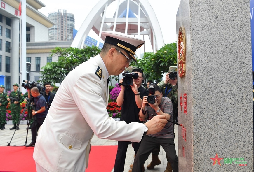 Bộ trưởng Đổng Quân tô sơn cột mốc 102 (1) bên phía Trung Quốc. Ảnh: TRỌNG HẢI
