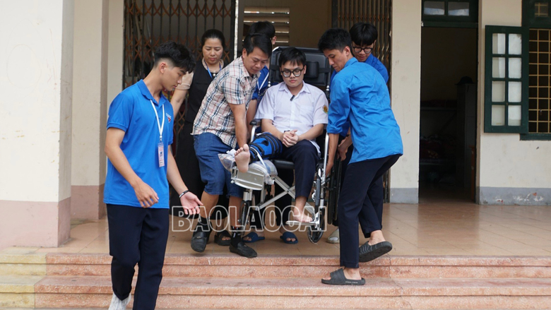 Các tình nguyện viên tại điểm thi Trường THPT Chuyên Lào Cai hỗ trợ đưa Trung Nghĩa đến phòng thi.